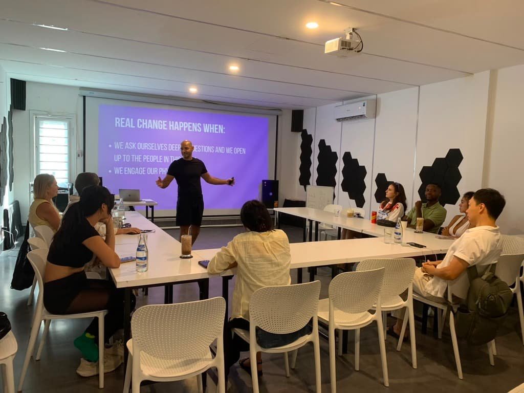 Gilad presenting 'Real change happens when' to a seated group